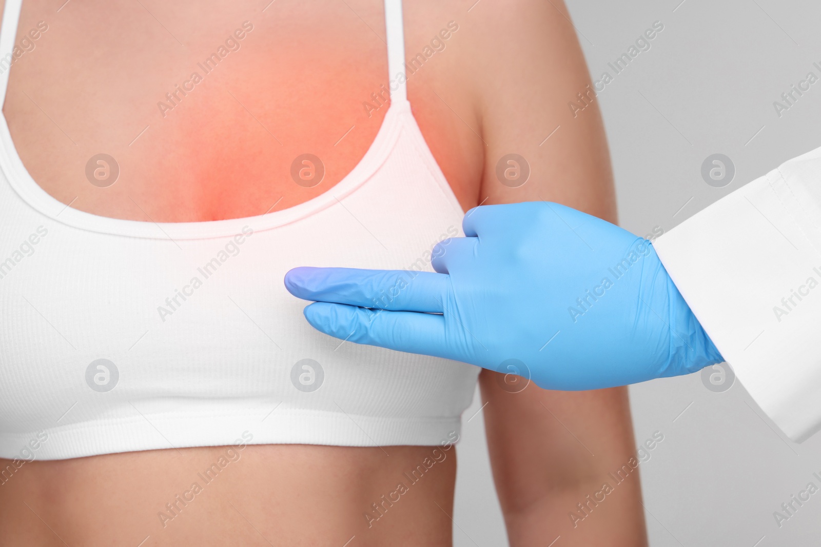 Image of Woman suffering from pain visiting breast specialist on light grey background, closeup