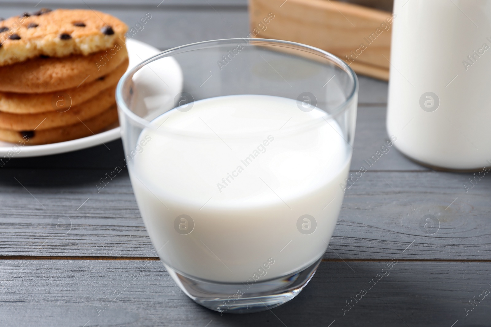 Photo of Glass of delicious milk on grey wooden table