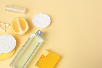 Lemon face cleanser. Fresh citrus fruits and personal care products on beige background, above view with space for text