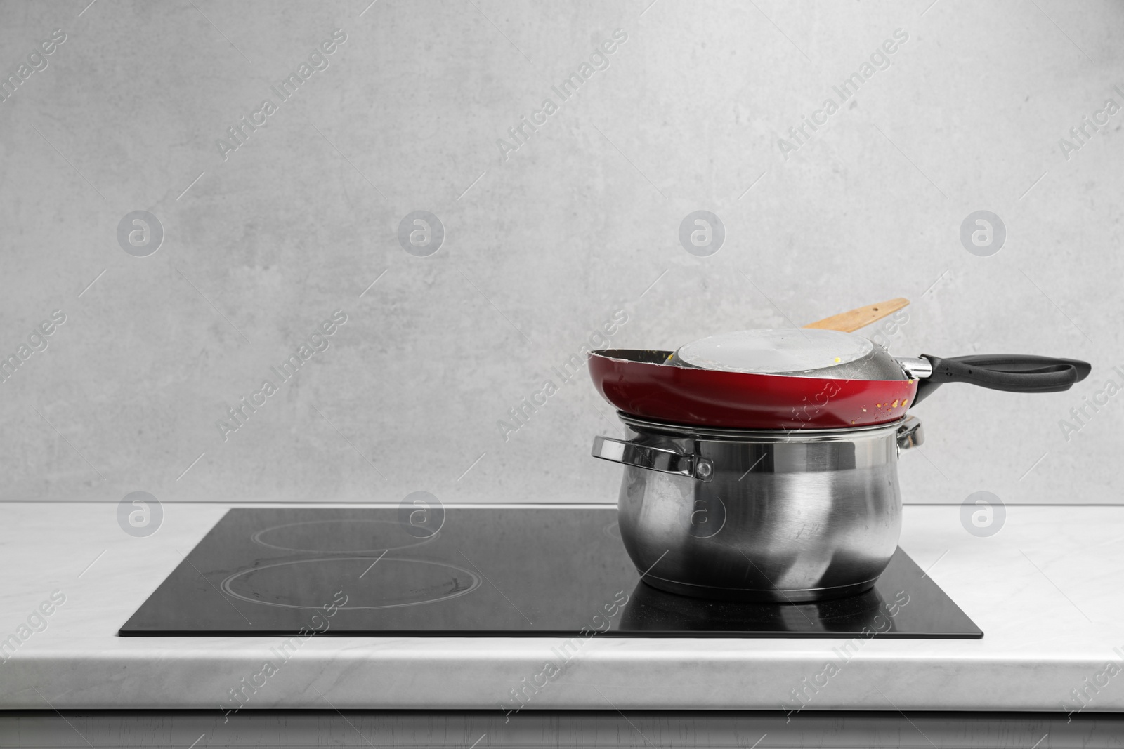 Photo of Stack of dirty kitchenware on cooktop in kitchen, space for text