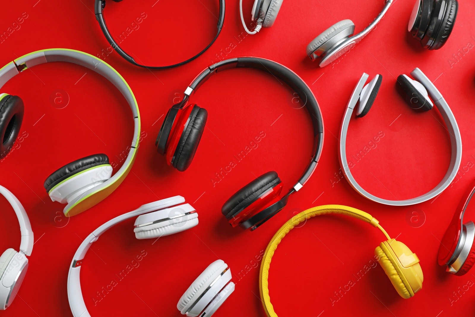 Photo of Many different headphones on color background, top view