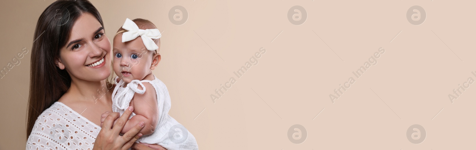 Photo of Beautiful mother with her cute baby on beige background