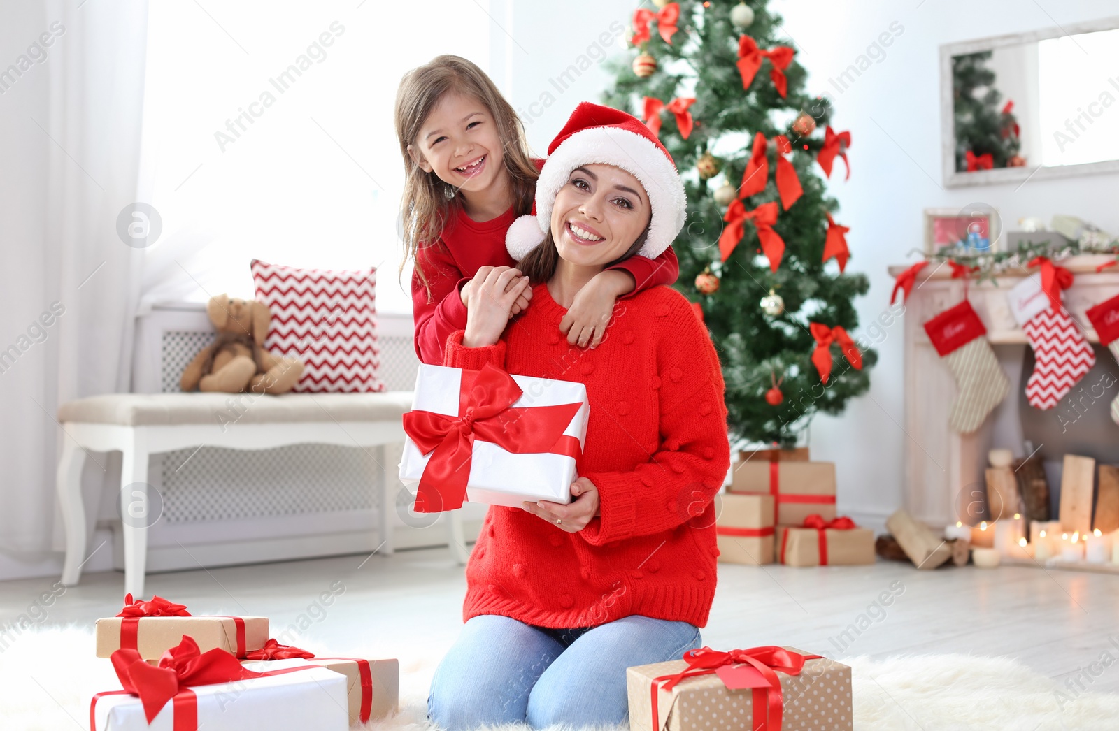 Photo of Happy mother and child with gifts celebrating Christmas at home