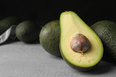 Delicious ripe avocados on grey wooden table