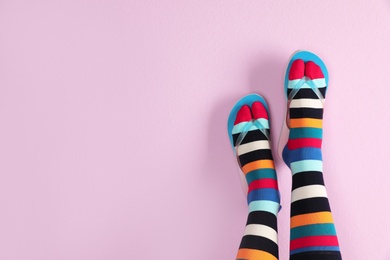 Woman wearing bright socks with flip-flops and space for design on color background