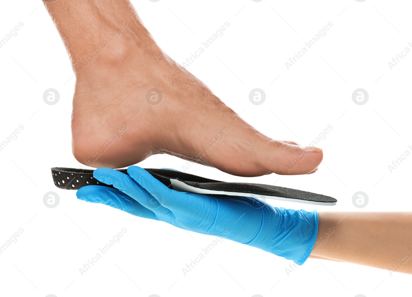 Photo of Orthopedist fitting insole on patient's foot against white background, closeup