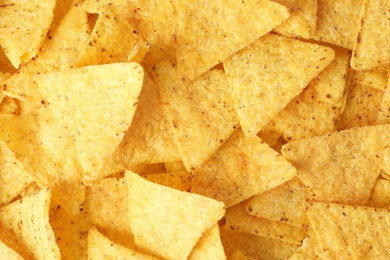 Photo of Tasty Mexican nachos chips as background, top view