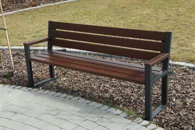 Empty wooden bench in park on spring day