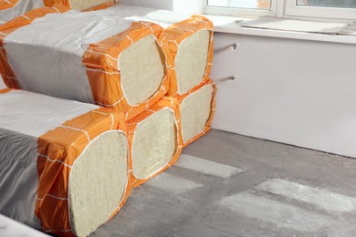 Photo of Packages of thermal insulation material in room. Space for text