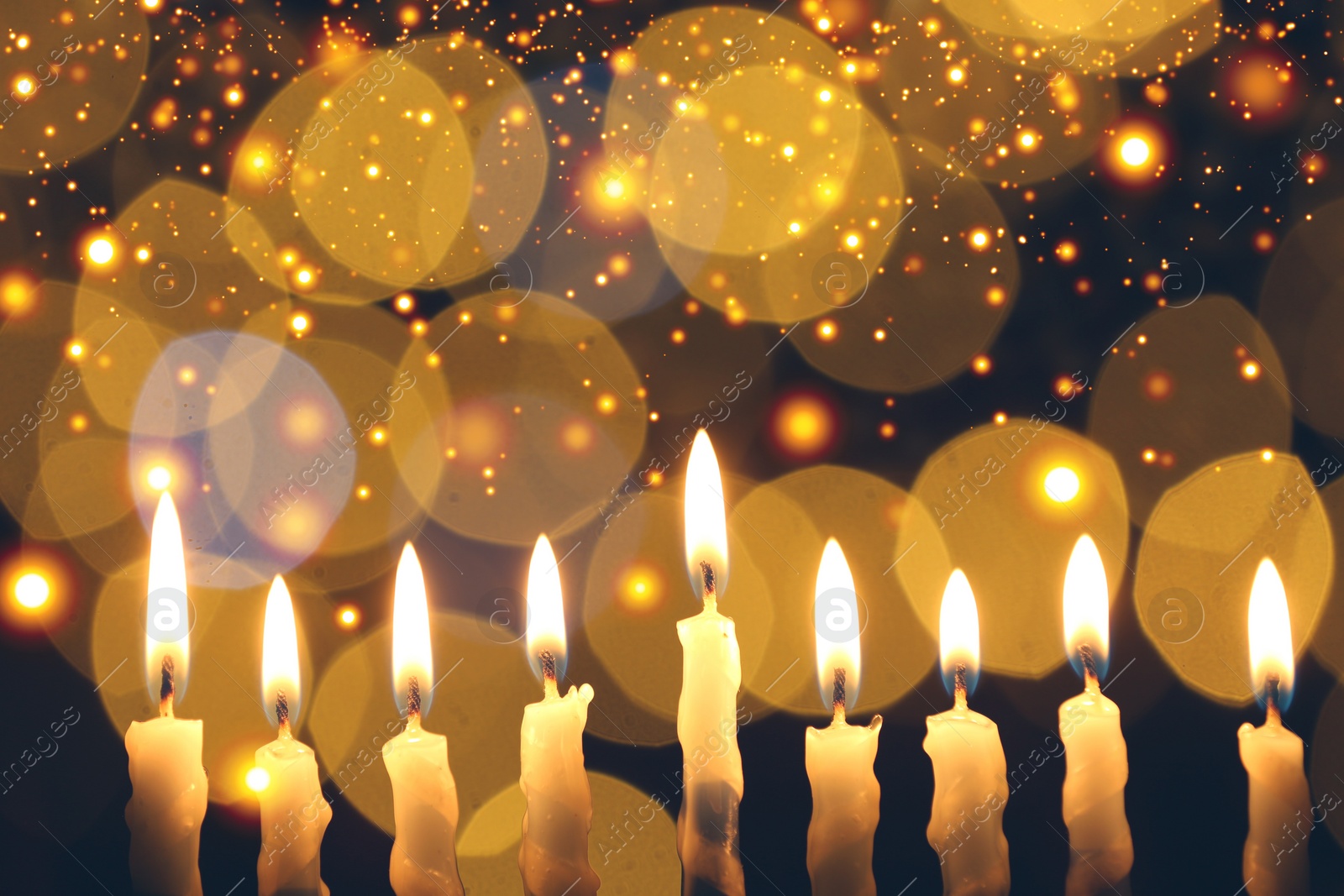 Image of Hanukkah celebration. Burning candles against blurred lights, closeup