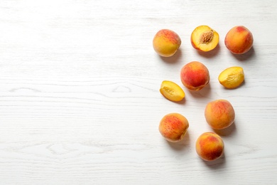 Fresh sweet peaches on wooden table, top view