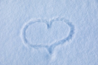 Heart drawn on snow, top view. Winter season