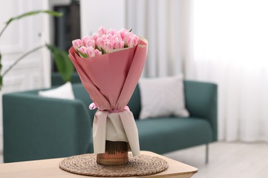 Beautiful bouquet of fresh pink tulips on table at home