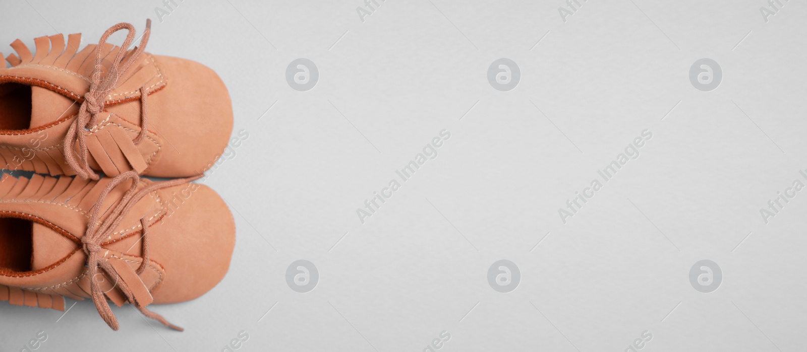 Image of Cute baby shoes on grey background, top view. Banner design with space for text