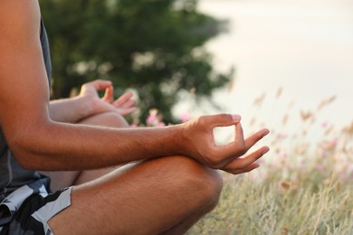 Photo of Man meditating outdoors on summer day, closeup