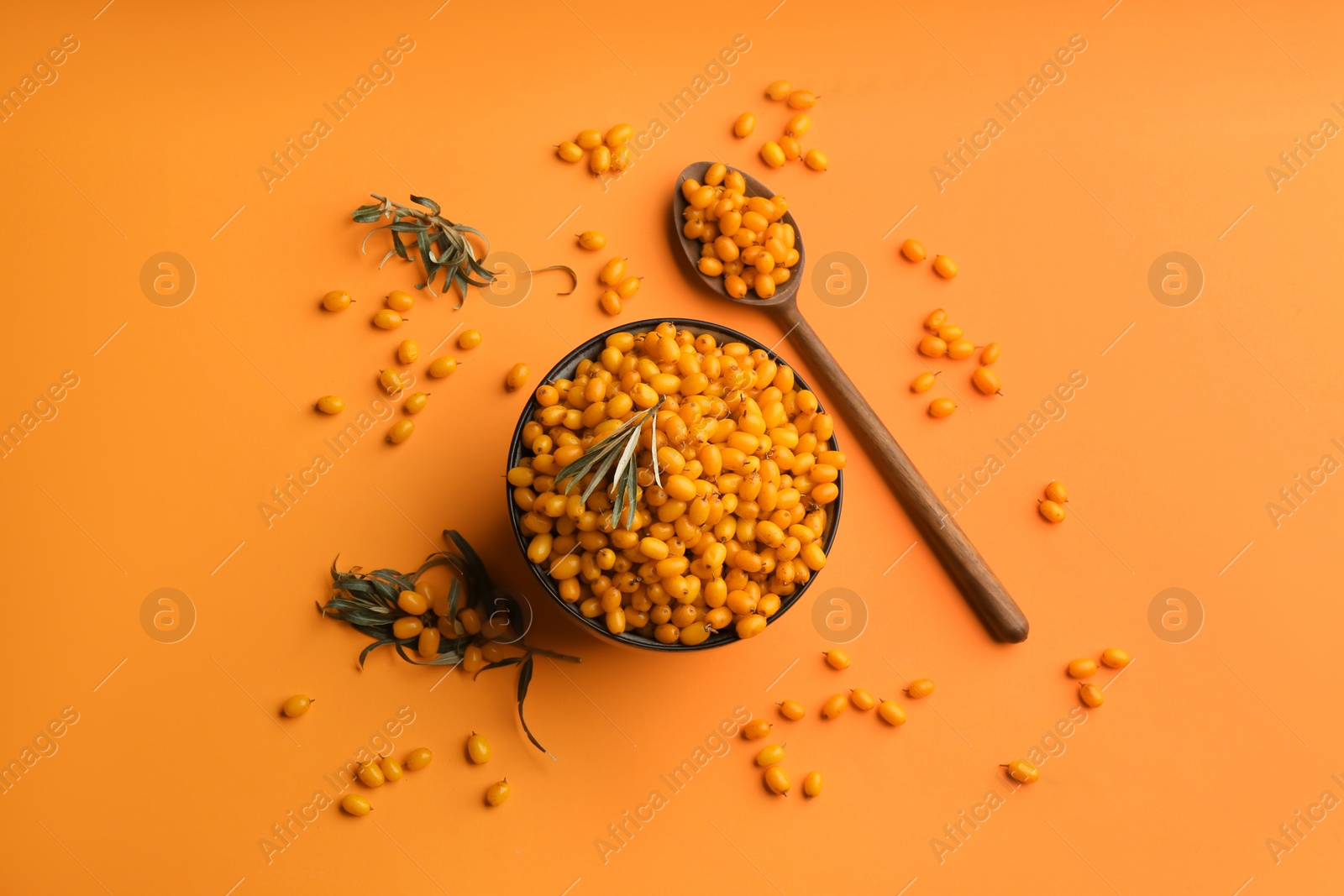 Photo of Fresh ripe sea buckthorn on orange background, flat lay