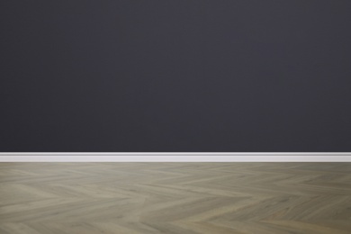 Image of Wooden floor and empty dark wall indoors