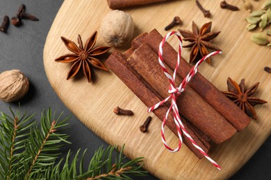 Photo of Different spices, nuts and fir branches on table, flat lay