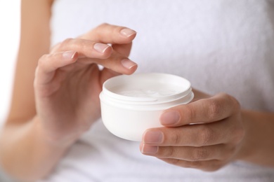 Photo of Woman with jar of moisturizing cream, closeup