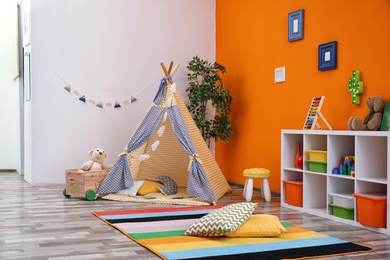 Cozy kids room interior with play tent and toys