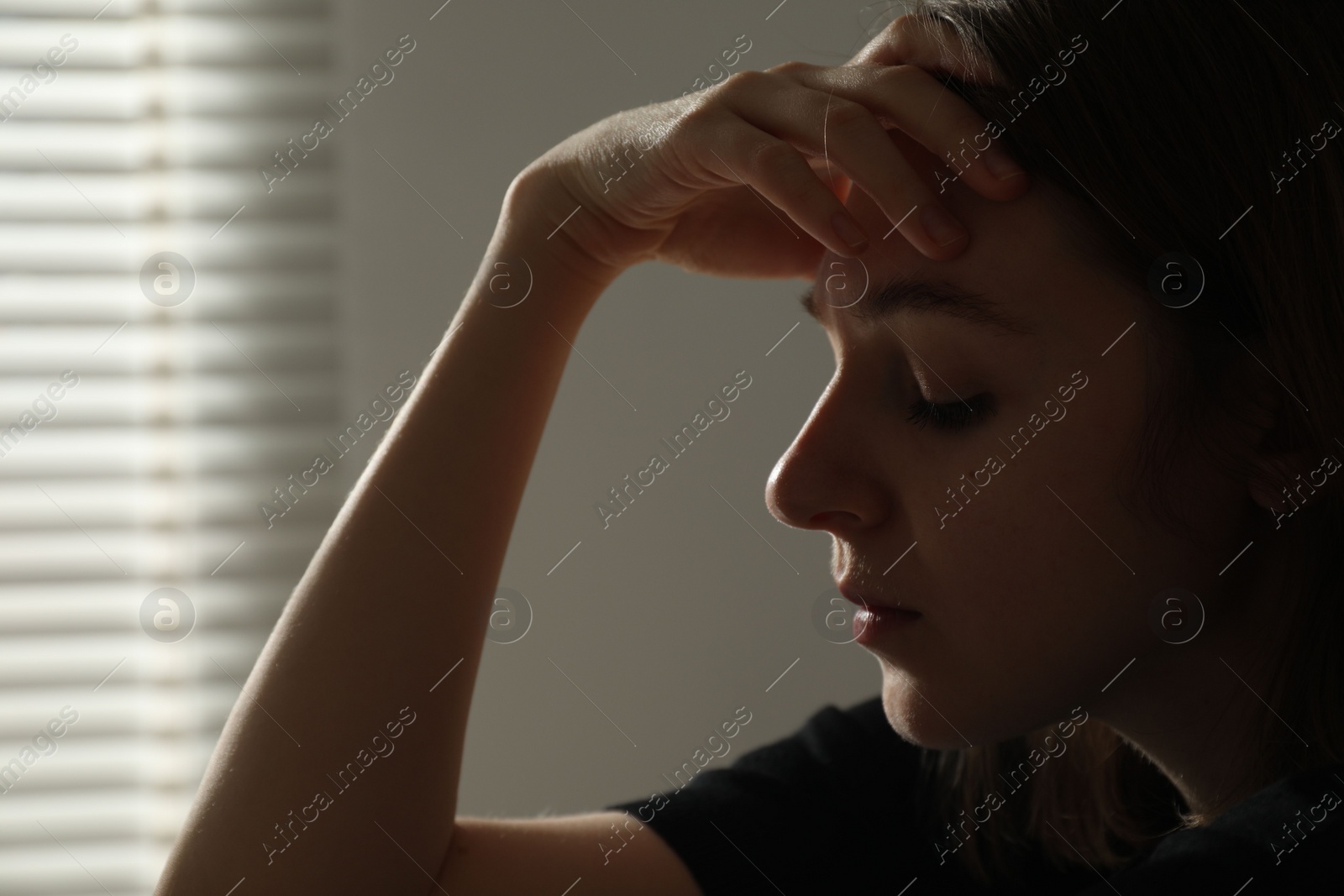 Photo of Sad young woman on blurred background, closeup