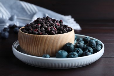Freeze dried and fresh blueberries on wooden table