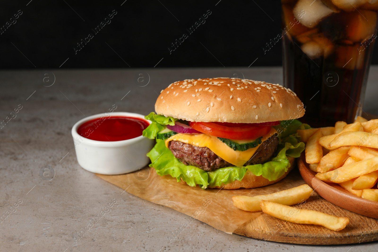 Photo of Delicious burger, soda drink and french fries served on grey table. Space for text