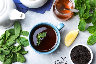 Fresh tea with mint, honey and lemon on light table, flat lay