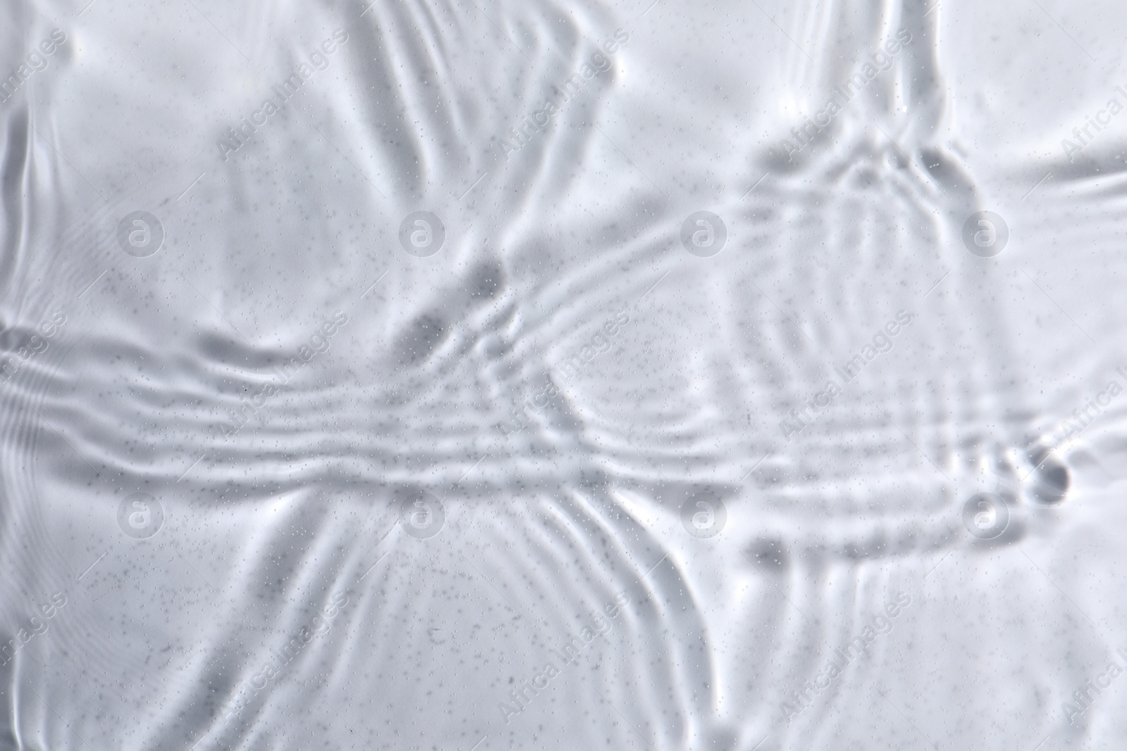 Photo of Closeup view of water with rippled surface on light background