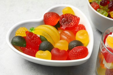 Photo of Delicious fruity gummy candies on light grey table, closeup