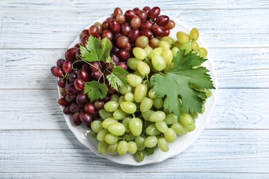 Photo of Fresh ripe juicy grapes on white wooden table, top view