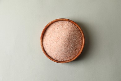 Himalayan salt in bowl on grey background, top view