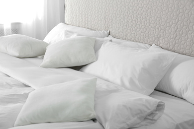 Photo of Bed with soft fluffy pillows at home