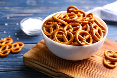 Photo of Delicious pretzel crackers on blue wooden table, closeup