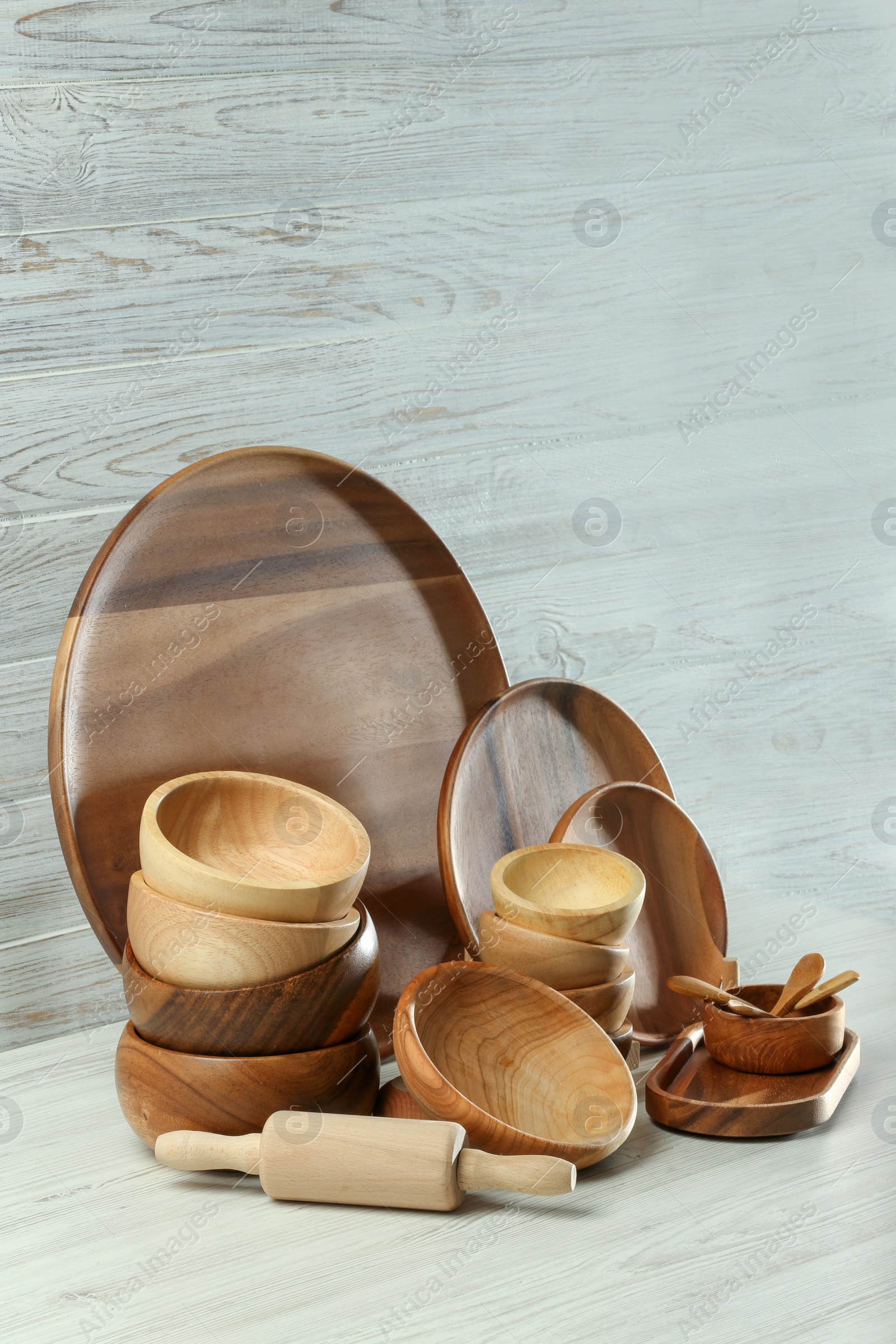 Photo of Set of clean wooden dishware and utensils on table