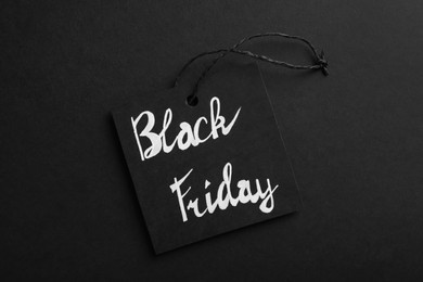 Black Friday tag on color background, top view