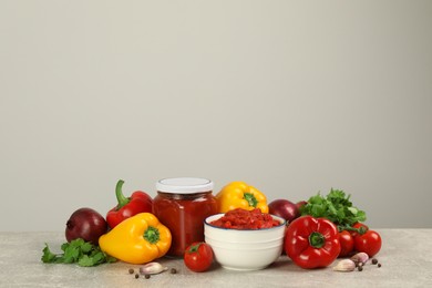 Photo of Delicious lecho and fresh ingredients on light grey table. Space for text