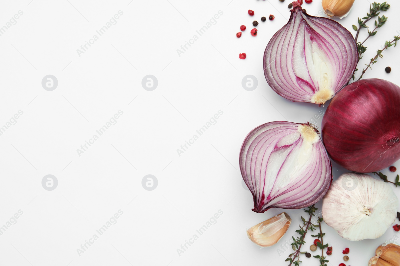 Photo of Fresh red onions, garlic, thyme and spices on white background, flat lay. Space for text