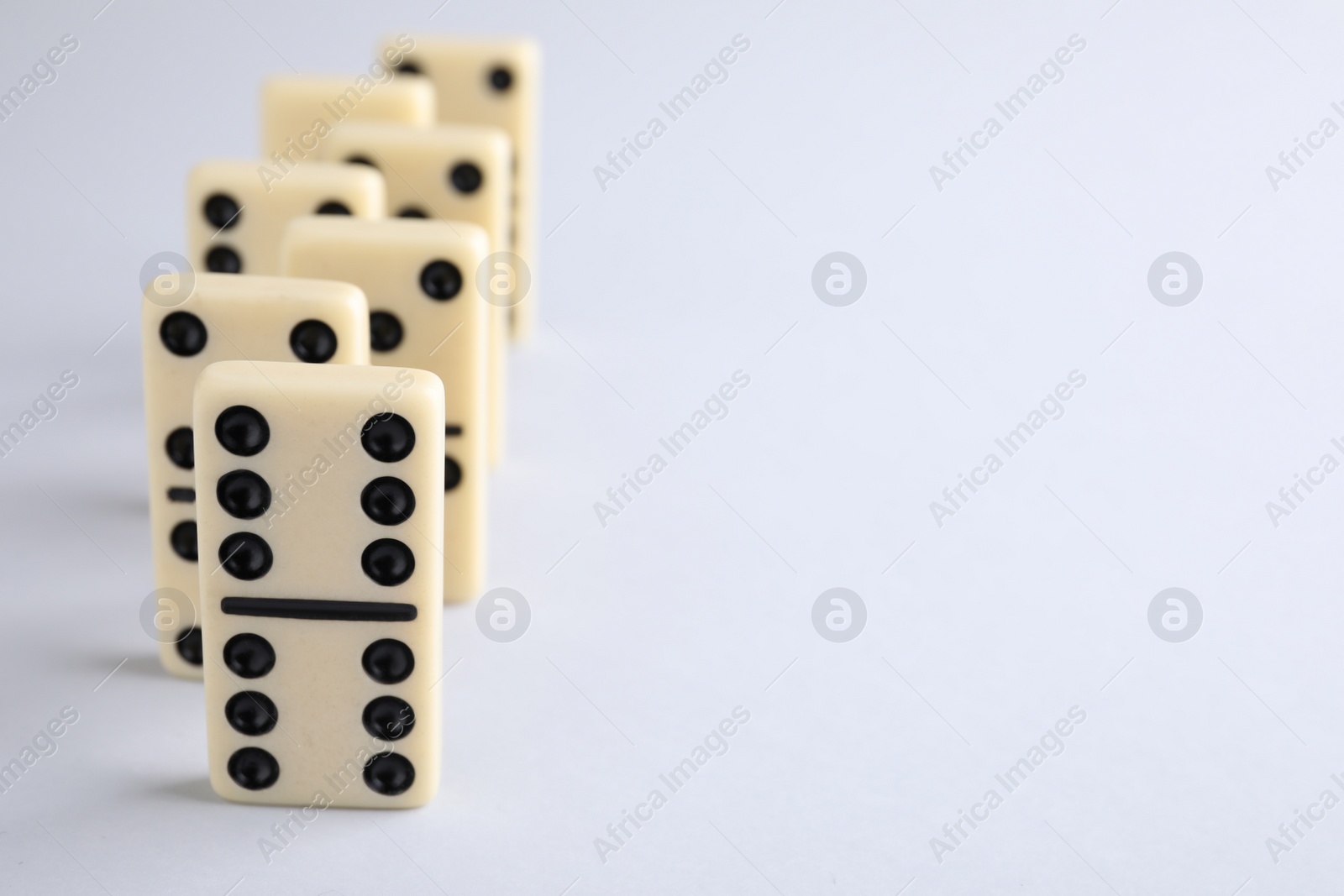 Photo of Domino tiles on white background. Space for text