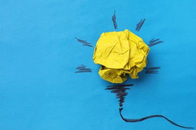 Photo of Idea concept. Light bulb made with crumpled paper and drawing on blue background, top view. Space for text