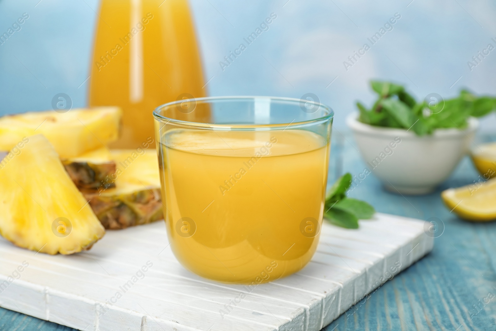 Photo of Glass with delicious pineapple juice on table