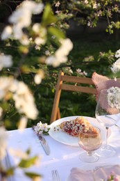 Photo of Stylish table setting with beautiful spring flowers in garden