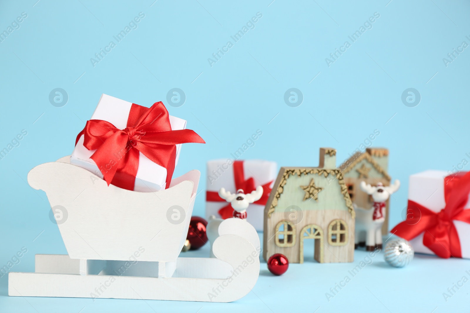 Photo of Beautiful Christmas composition with miniature sleigh on light blue background