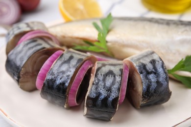 Tasty salted mackerel, parsley and onion on plate, closeup