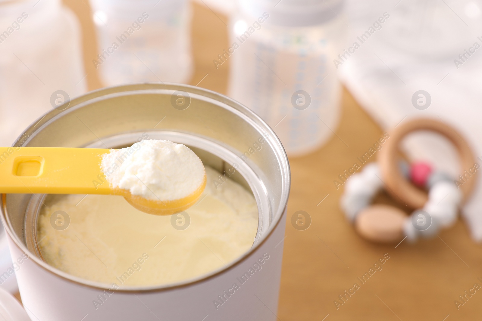 Photo of Can of powdered infant formula with scoop on table, closeup. Baby milk