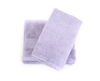 Folded violet terry towels isolated on white, top view