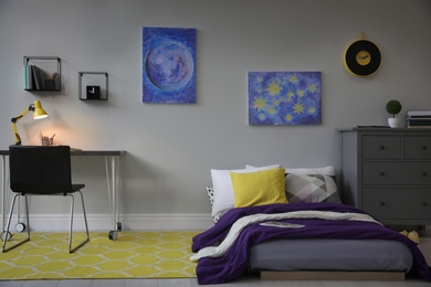 Modern teenager's room interior with comfortable bed, workplace and stylish design elements