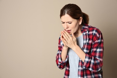 Photo of Woman suffering from cough on color background. Space for text