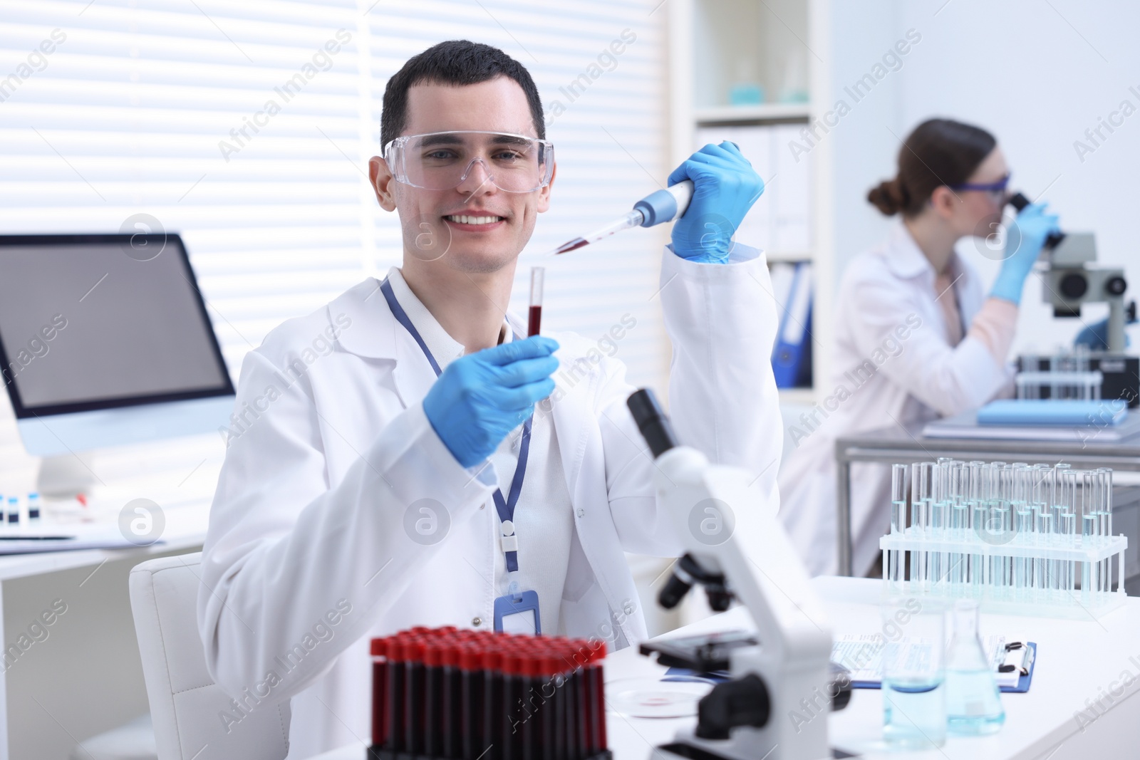 Photo of Scientist dripping sample into test tube in laboratory