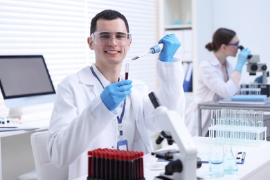 Photo of Scientist dripping sample into test tube in laboratory